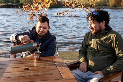 Two friends enjoying the sunset while drinking mate