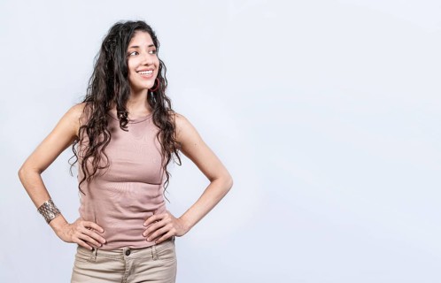 Thoughtful smiling girl looking at a blank space. Young woman looking at an advertisement to the side