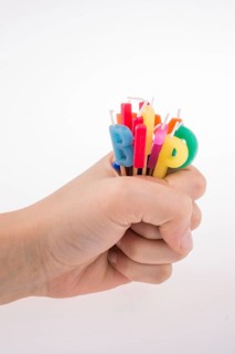 Hand holding letters made of candles on sticks