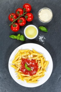 Penne Rigatoni Rigate Italian pasta in tomato sauce eat lunch dish on plate slate from above in Stuttgart