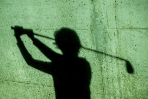 Shadow of a Golfer on a Wall Holding a Golf Club