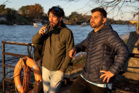 Two friends enjoying the sunset while drinking mate
