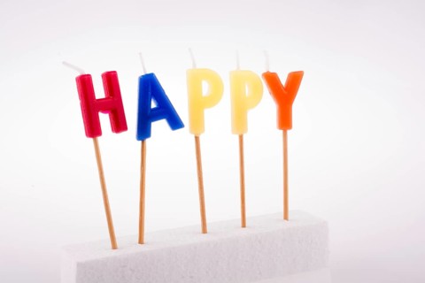 Color candles on sticks write the word happy