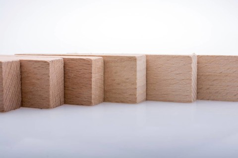 Wooden Domino Blocks in a line on a white background