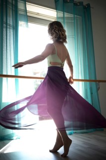 Woman Dancing with Transparent Skirt in Front of a Window with Curtain