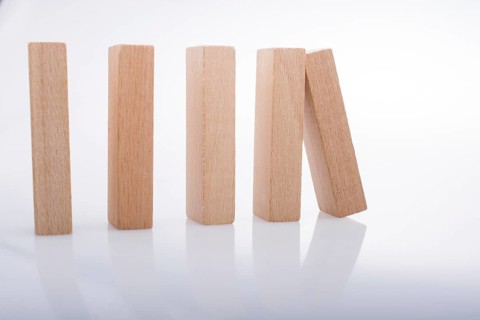 Wooden Domino Blocks in a line on a white background