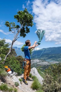 Climber throws climbing rope over his shoulder