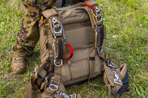 Military Parachuter Standing on the Grass with His Parachute in Switzerland