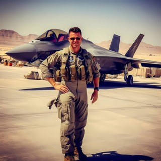 Young proud pilot stands in front of his F 35 fighter plane