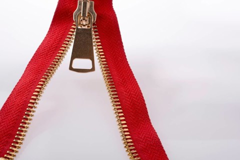 Hand holding color zipper on a white background
