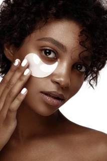 African American skincare models with perfect skin and curly hair with patches under her eyes
