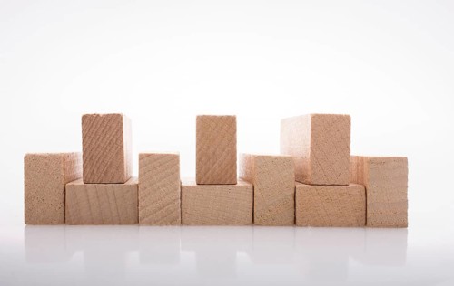 Wooden Domino Blocks in a line on a white background
