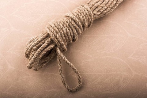 Bundle of linen rope in a sbrown background