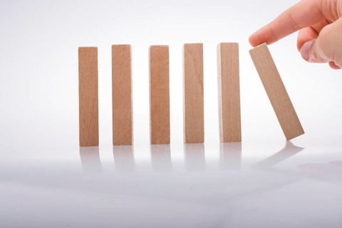 Hand holding wooden domino on a white background