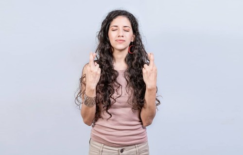 Hopeful woman making a wish isolated
