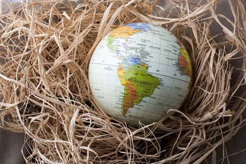 Little model globe is put on a straw background