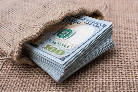 Banknote bundle of US dollarin a sack on a canvas