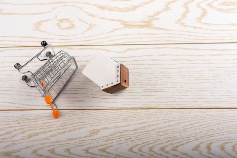 Little model house and a trolley and on a parquet background