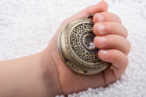 Retro style pocket watch in hand on white background