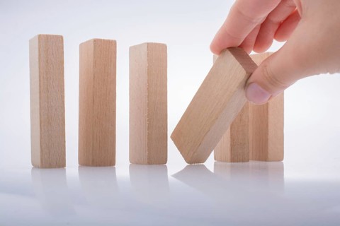 Hand holding wooden domino on a white background