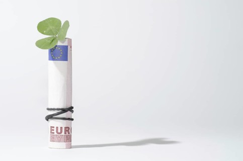 The Bill of Rolled Ten Euro with Three Leaf Clover and Rubber Band with Shadow