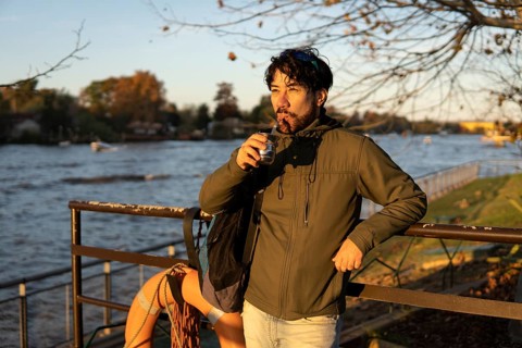 Latin man enjoying the sunset at the river while drinking mate