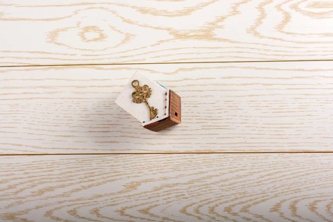 Model house and key and on parquet background
