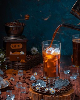 Coffee is poured into glass with ice cube cubes