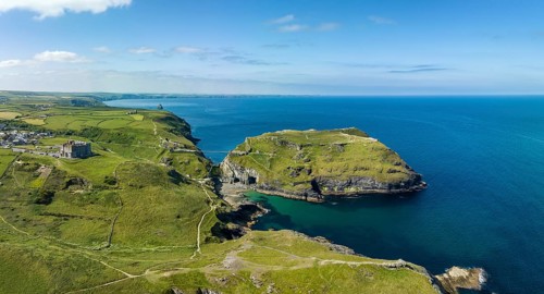 Aerial panorama of the rugged coastline on the Celtic Sea with the Tintagel Peninsula and the ruins of Tintagel Castle