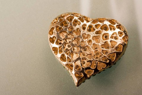 Gold color metal heart shaped object in view
