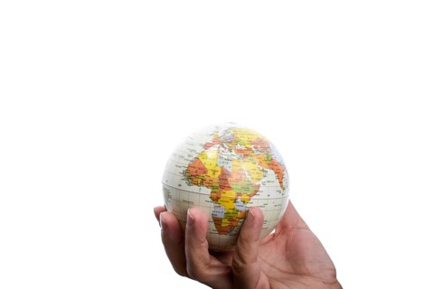 Child holding a small model globe in hand on white background