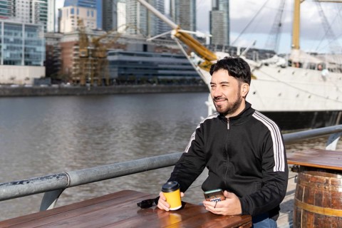 Latin tourist drinking coffee at an outdoor bar in Puerto Madero