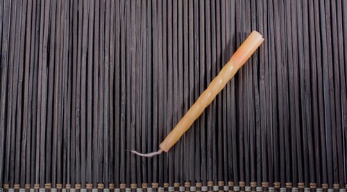 Colorful birthday candle placed on a straw mat