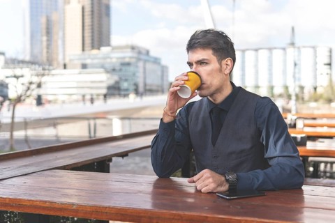 Businessman sitting at an outdoor bar having a coffee