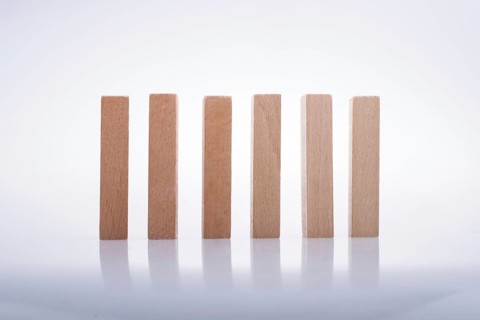 Wooden Domino Blocks in a line on a white background