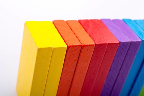 Colorful Domino Blocks in a line on a white background