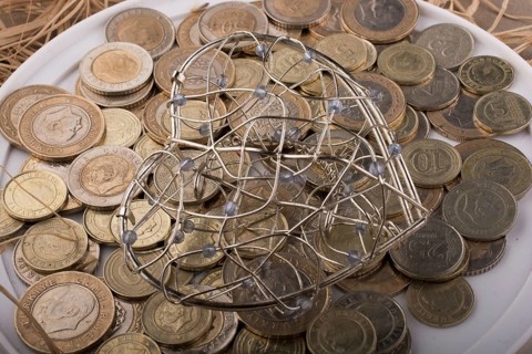 Turkish Lira coins by the side of a red color heart shaped object on white background