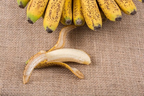 Bunch of yellow freckled bananas on a canvas texture