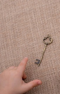 Heart shaped gold color metal object in hand