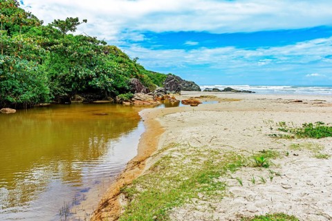 River going towards the sea with the sand