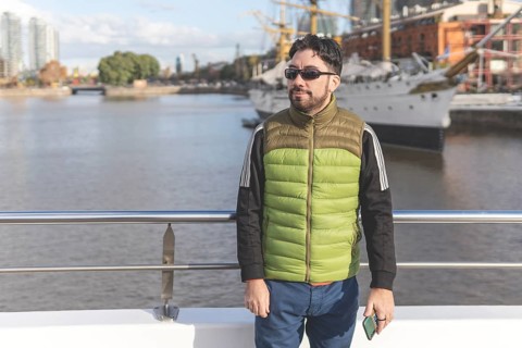 Happy tourist posing in front of a boat in Puerto Madero