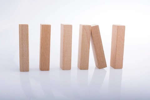 Wooden Domino Blocks in a line on a white background