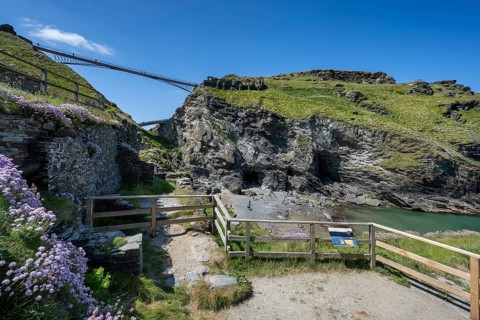 Viewing platforms on the cliffs of Tintagel with the old and new footbridge to the ruins of Tintagel Castle and the fabled Merlins Cave