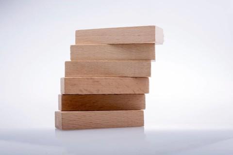 Wooden Domino Blocks in a line on a white background