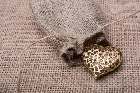Heart shaped gold color metal object out of sack