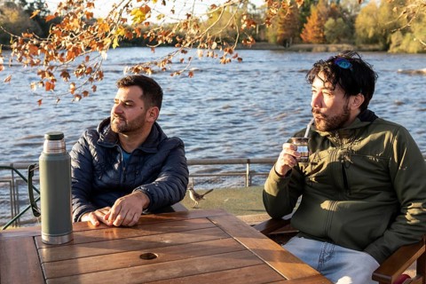 Two friends enjoying the sunset while drinking mate