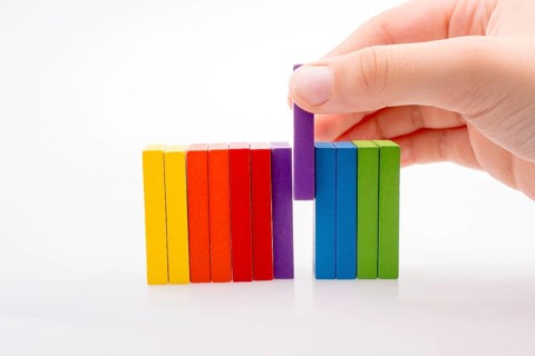 Hand holding color dominoes on a white background