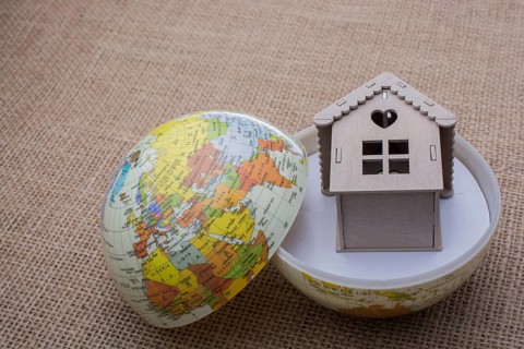 Model house and a globe on a linen canvas