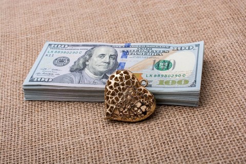 Heart icon bundle of US dollar placed on a linen canvas