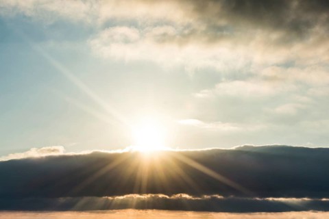 Sun behind beautiful white clouds in midday